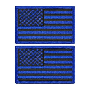 May include: Two blue and black American flag patches. The flags are embroidered with black thread on a blue background.