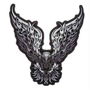 May include: Black and white embroidered patch of a stylized eagle with wings spread wide. The eagle has a tribal design with flames on its wings.