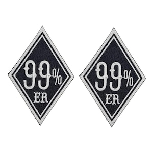 May include: Two black diamond-shaped patches with white embroidered text. The text on each patch reads "99% ER".