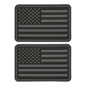 May include: Two black and gray American flag patches. The flags are made of a textured material and have a grid pattern.