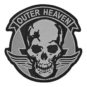 May include: A black and gray embroidered patch with a skull and wings. The text "Outer Heaven" is written in a circle around the skull.