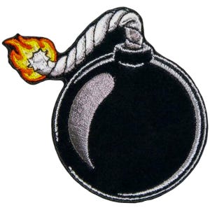 May include: Embroidered patch featuring a black bomb with a lit fuse and a flame. The bomb has a silver outline and a silver curved highlight. The fuse is a twisted white rope. The flame is yellow, orange, and red.