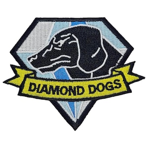 May include: A black and white embroidered patch with a diamond shape. The diamond has a blue and white design inside. A black dog's head is in the center of the diamond. A yellow banner with the text "DIAMOND DOGS" is below the diamond.