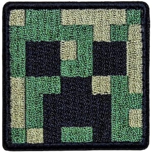 May include: Square patch featuring a pixelated design of a Creeper from the video game Minecraft. The patch has a black border and a green, tan, and black color scheme. The design is made up of small squares.