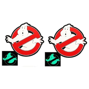 May include: Two red and white Ghostbusters no ghost signs with a green glow in the dark version of the sign in the bottom corners.