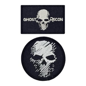 May include: Two black embroidered patches with a white skull design. One patch is rectangular and says "Ghost Recon". The other patch is round and features a skull with a stylized design.