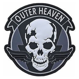 May include: Black and gray embroidered patch with a white skull and wings. The text "Outer Heaven" is written in a white, curved banner above the skull.