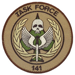 May include: A tan embroidered patch with the words "Task Force" in brown lettering around a green clover with a white skull and crossbones and wings. The number "141" is below the clover.