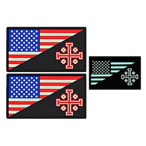 May include: Two black patches with an American flag and a red cross on a white background. The patches are sewn together with a diagonal seam. Below the patches is a smaller black patch with a white cross on a blue background.