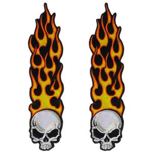 May include: Two identical embroidered patches, each featuring a white skull at the base with black eye sockets and teeth, topped with a tall, vertical design of stylized orange and yellow flames outlined in black against a black background.