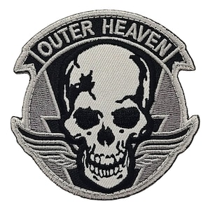May include: A black and white embroidered patch with a skull and wings. The text "OUTER HEAVEN" is written in a circle around the skull.