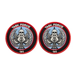 May include: Two black and red embroidered patches with the words "Task Force" and the number "141" in white. Each patch features a skull with wings and a sword.