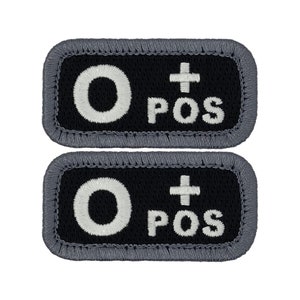 May include: Two black rectangular patches with white embroidered text. The text reads "O+ POS".
