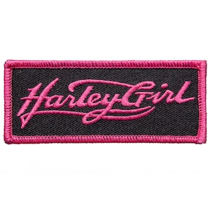 May include: A rectangular embroidered patch featuring a black fabric background with a bright pink border. The text Harley Girl is stitched in a cursive pink font across the center of the patch, creating a bold contrast against the black.