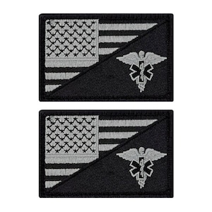 May include: Two black and silver embroidered patches with an American flag and a medical symbol. The flag is on the left side of the patch and the medical symbol is on the right side. The medical symbol is a caduceus with a snake wrapped around it.