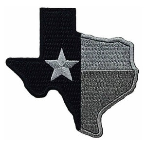 May include: A black and white embroidered patch in the shape of the state of Texas with a white star in the center.