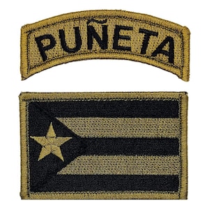 May include: Two embroidered patches. The top patch is a tan curved patch with black text that reads "PUNE TA". The bottom patch is a tan rectangular patch with a black outline and a black and tan Puerto Rican flag design.