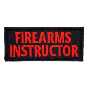 May include: Black embroidered patch with red text that reads "FIREARMS INSTRUCTOR".