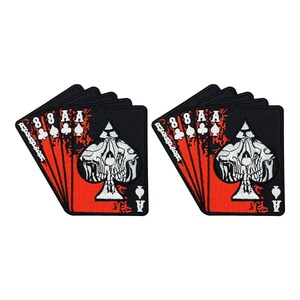 May include: Two black and red patches in the shape of playing cards. Each patch features a skull design on the Ace of Spades, with the numbers 8 and the Ace of each suit. The patches have a distressed, grunge aesthetic.