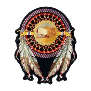 May include: Embroidered patch featuring a Native American dreamcatcher with a buffalo inside the circle, surrounded by two feathers. The dreamcatcher is red, yellow, and blue, with black beads. The feathers are white and brown.