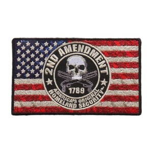 May include: An embroidered patch with an American flag background. The center of the patch features a black circle with a skull and crossbones, the text "2nd Amendment", "America's Original Homeland Security", and the year "1789".