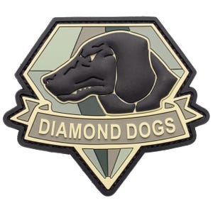May include: A pentagonal rubber patch featuring a black dog silhouette against a muted green and gray geometric background. A banner across the center displays the text DIAMOND DOGS in raised lettering, framed by a thick black border.
