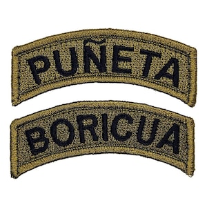 May include: Two embroidered patches with arched shapes. The top patch reads "PUÑETA" in black letters on a gold background. The bottom patch reads "BORICUA" in black letters on a gold background. The patches are likely for clothing or accessories.