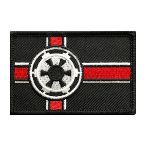 May include: Black embroidered patch with a white Imperial symbol and red stripes. The symbol is a circle with a gear inside and four arms extending from the gear.