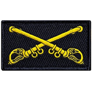 May include: A black embroidered patch with two crossed gold sabers. The sabers have a gold snake design on the hilt.