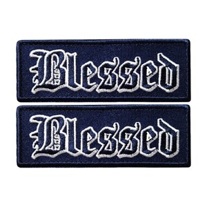 May include: Two navy blue iron-on patches with white embroidered lettering that reads "Blessed" in a gothic font.