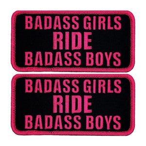 May include: Two black fabric patches with pink embroidered text. The text reads "Badass Girls Ride Badass Boys".