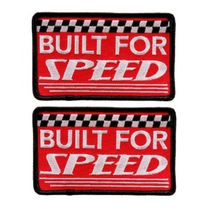 May include: Two red and black embroidered iron-on patches with white text that reads "Built for Speed" and a checkered flag design.