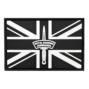 May include: Black and white patch with a Union Jack flag design. The center of the patch features a white dagger and a white patch with the text "ROYAL MARINES COMMANDO".