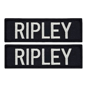 May include: Two black fabric patches with white embroidered text that reads "RIPLEY".