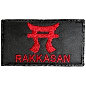 May include: A black embroidered patch with a red Japanese torii gate and the word "RAKKASAN" in red.