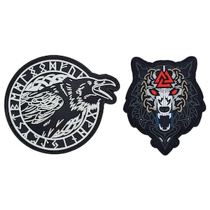 May include: Two black and white embroidered patches with a Norse theme. One patch features a raven with its wings spread and a circle of runes around it. The other patch features a wolf's head with a red triangle symbol in the center.
