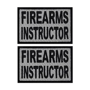May include: Two gray and black embroidered patches with the text "FIREARMS INSTRUCTOR" in black.
