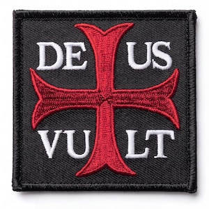 May include: A square embroidered patch with a black background and a red cross in the center. The white text DE US is stitched above the cross, and the white text VU LT is stitched below the cross, creating the phrase DEUS VULT on the patch.