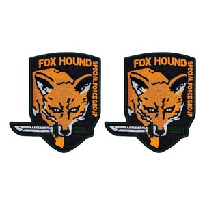May include: Two black and green embroidered patches with the words "FOX HOUND SPECIAL FORCE GROUP" and a stylized orange fox head with a knife in its mouth.