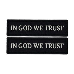 May include: Two black rectangular patches with white embroidered text that reads "In God We Trust".