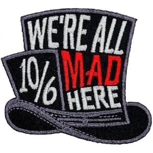 May include: A black and white embroidered patch shaped like a top hat with the text "We're All 10/6 Mad Here" in white and red lettering.