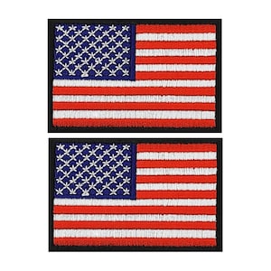 May include: Two embroidered patches featuring the American flag. Each patch has a blue canton with white stars and red and white stripes. The patches are rectangular with a black border.