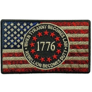 May include: An embroidered patch with an American flag design. The center of the patch features a circle with the text "When Tyranny Becomes Law, Rebellion Becomes Duty" and the year "1776" surrounded by red stars.
