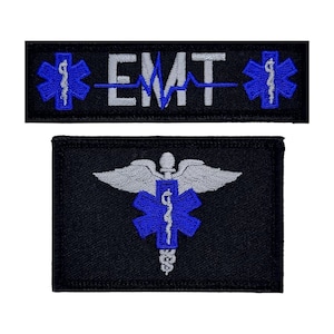 May include: Two black embroidered patches. The top patch reads "EMT" in white, with a blue heartbeat line and blue star of life symbols. The bottom patch features a blue star of life symbol with a caduceus and gray wings.