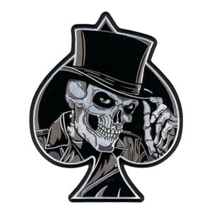 May include: Embroidered patch featuring a skull wearing a top hat and a jacket, set against a black spade shape. The skull is detailed in shades of gray and white, with the hat and background in black.