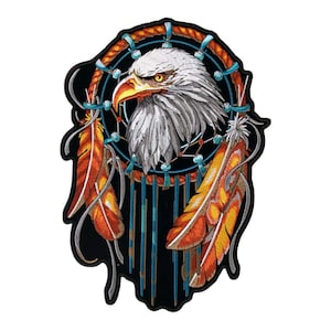 May include: Embroidered patch featuring a detailed bald eagle head within a dreamcatcher design. The eagle has white and gray feathers, a yellow beak, and piercing yellow eyes. The dreamcatcher includes orange and yellow feathers, and blue accents.