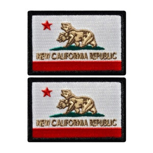 May include: Two embroidered patches featuring the New California Republic flag. Each patch has a white background with a red star and a brown bear emblem. The text "NEW CALIFORNIA REPUBLIC" is displayed.
