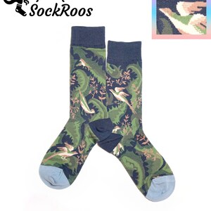 May include: A pair of crew socks featuring a dark navy blue background with a repeating pattern of green foliage and light-coloured birds. The socks have solid dark navy blue cuffs and light blue toe sections. The brand name SockRoos is visible.