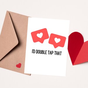 May include: A white card with two red social media like buttons with white hearts inside. The text "I'd double tap that" is printed below the buttons.
