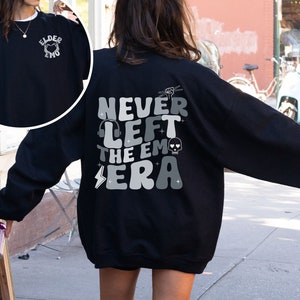 May include: Black sweatshirt with a graphic print on the back that says "Never Left The Emo Era" and a smaller graphic print on the front that says "Elder Emo".